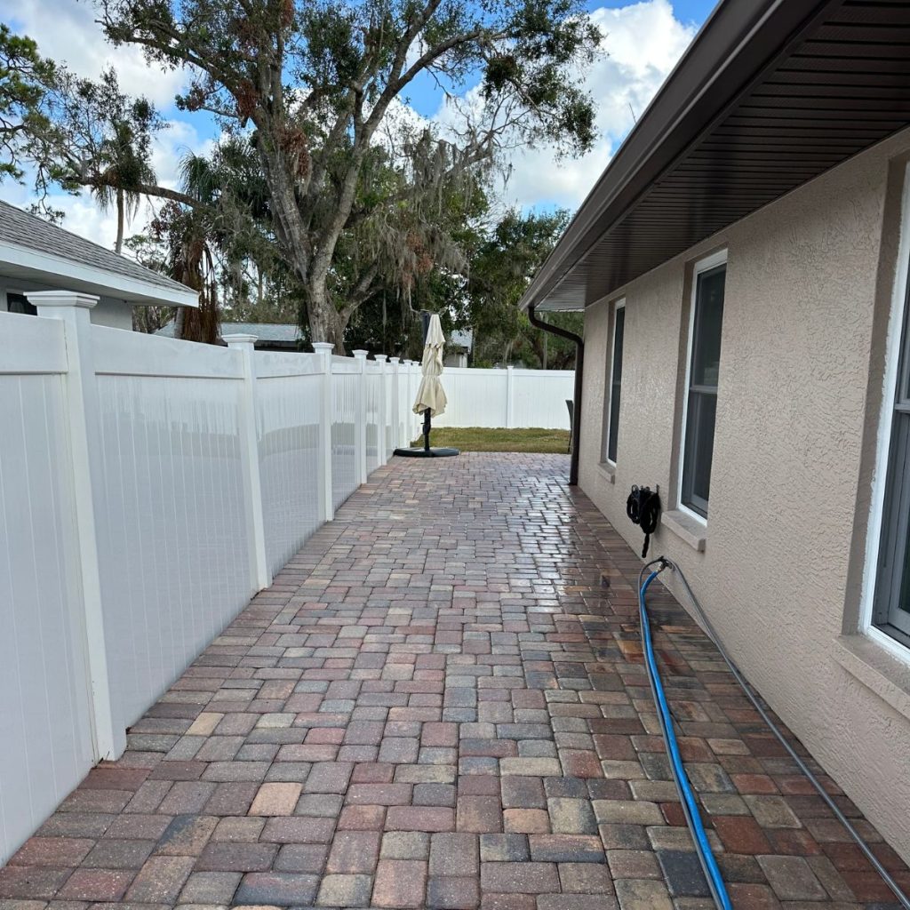 Freshly pressure washed brick paver patio and vinyl fence cleaning by Eastport Cleaning in Lakewood Ranch FL